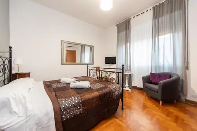 a bedroom with a bed and a chair at L'Imperiale RomaTrastevere in Rome