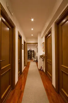 a hallway with doors and a carpet in a house at B&B Roma Appia Davila25 in Rome