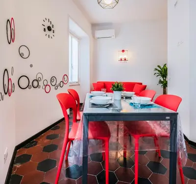 a dining room with red chairs and a glass table at Lele Rooms San Lorenzo in Rome