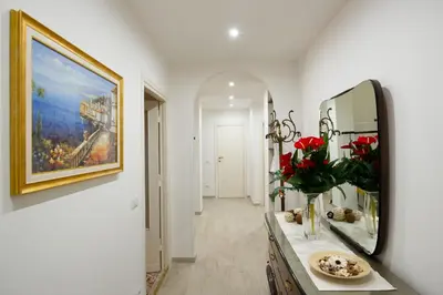 a bathroom with a mirror and a vase of flowers on a counter at House Bonifacio in Rome