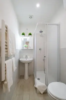 a white bathroom with a shower and a sink at House Bonifacio in Rome