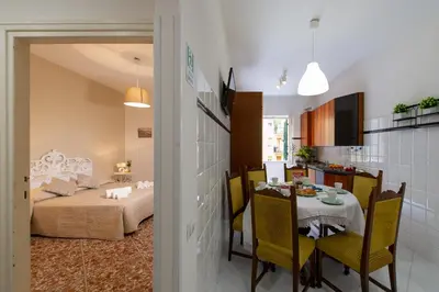 a room with a bed and a table and a kitchen at House Bonifacio in Rome