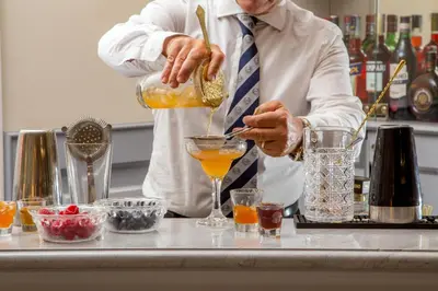 a man in a tie making a drink at Hotel Della Conciliazione in Rome