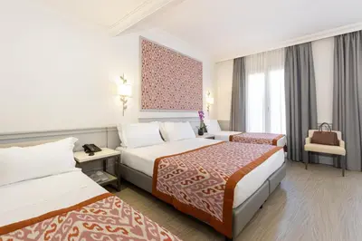 a hotel room with two beds and a chair at Hotel Della Conciliazione in Rome