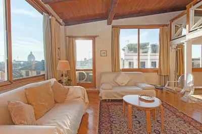a living room with a couch and a table at Amazing panoramic artist's loft Spanish Steps in Rome