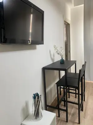 a black table and chairs with a television on a wall at Guest House Esty in Rome