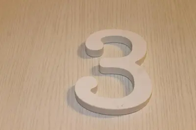 a white number sitting on a wooden floor at Guest House Esty in Rome