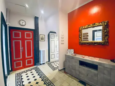 a hallway with a red door and a mirror at Virgilio Suite in Rome