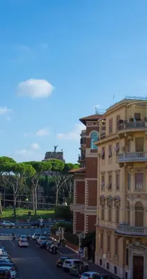 a city street with a building and cars on the road at Virgilio Suite in Rome
