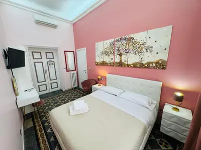 a bedroom with a white bed and a pink wall at Virgilio Suite in Rome