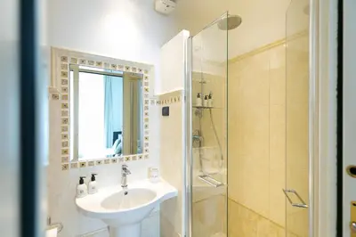 a bedroom with a large white bed with a window at Capitolium Rooms in Rome