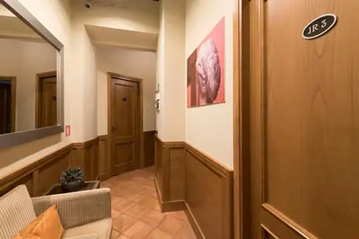 a hallway with a door and a couch and a mirror at JR Suites in Rome