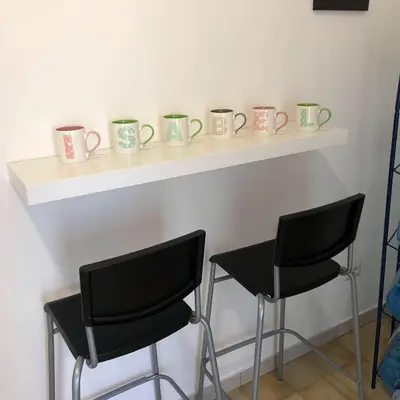 a counter with four chairs and mugs on it at Isabel in Rome