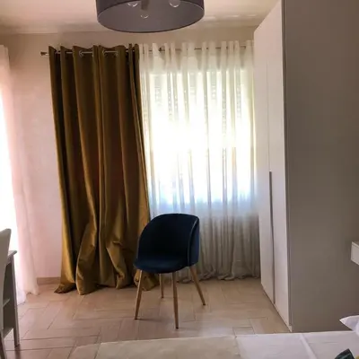 a blue chair sitting in front of a window at Isabel in Rome