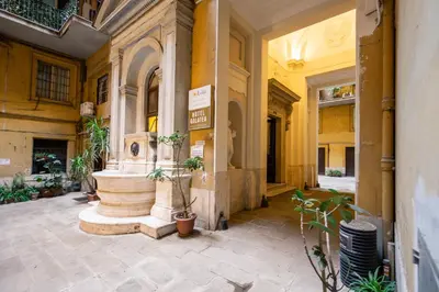 a building with a fountain in the middle of a courtyard at DeCharme apartment with terrace in Monti in Rome