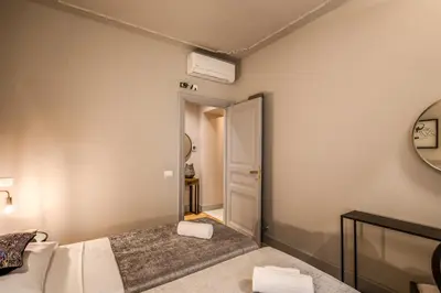 a small bedroom with a bed and a mirror at DeCharme apartment with terrace in Monti in Rome