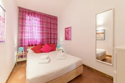 a bedroom with a large white bed with red pillows at Monti Stairway to Heaven in Rome
