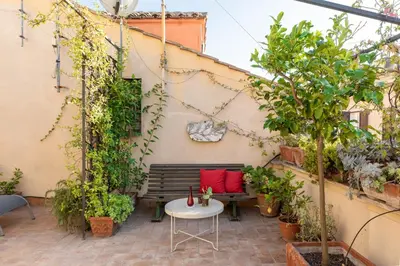 a patio with a bench and a table with plants at Monti Stairway to Heaven in Rome