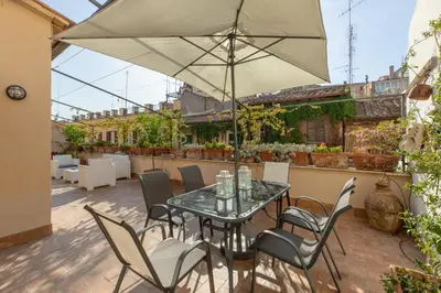 a patio with a table and chairs and an umbrella at Monti Stairway to Heaven in Rome