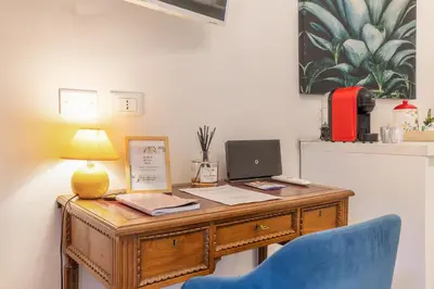 a wooden desk with a lamp and a blue chair at La Vaticana - Saint Peters View - Apt Rome in Rome