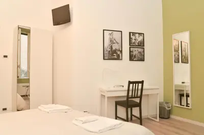 a bedroom with a bed and a desk and a chair at Colazione Al Vaticano Guest House in Rome