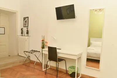 a room with a desk and a mirror and a bed at Colazione Al Vaticano Guest House in Rome