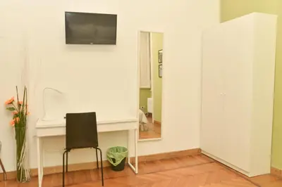 a white room with a chair and a mirror at Colazione Al Vaticano Guest House in Rome