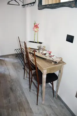 a wooden table with chairs and a vase with flowers at Damiva in Rome