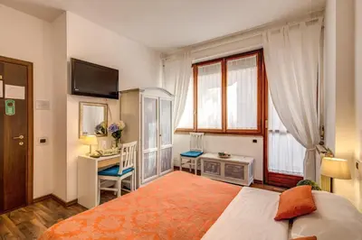 a bedroom with a bed and a desk and a window at Trastevere Rooms in Rome