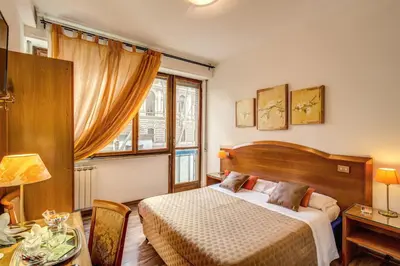 a bedroom with a bed and a table and a window at Trastevere Rooms in Rome