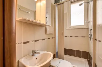 a bathroom with a sink and a toilet and a window at Trastevere Rooms in Rome