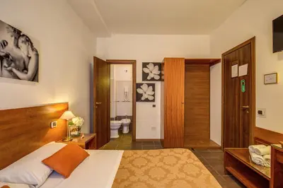a bedroom with a bed and a bathroom at Trastevere Rooms in Rome