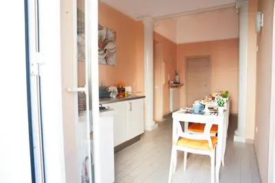 a small kitchen with a white table and a chair at Merulana Suite in Rome