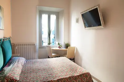 a bedroom with a bed and a table and a television at Merulana Suite in Rome