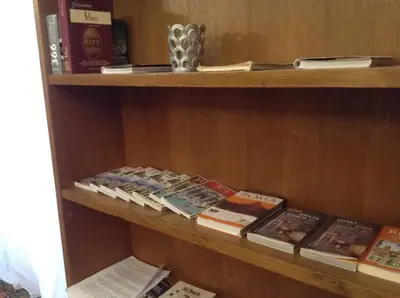 a book shelf with books and other books at Houspitality Caesar Bed & Breakfast in Rome