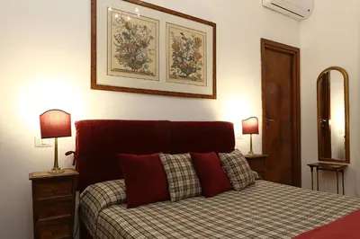 a bedroom with a bed with two lamps and a picture on the wall at Houspitality Caesar Bed & Breakfast in Rome