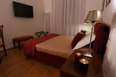a hotel room with a bed and a table with a lamp at Houspitality Caesar Bed & Breakfast in Rome