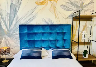 a bedroom with a bed with a blue headboard at Bon Ton Design Rooms by DOT Suites in Rome