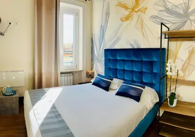 a bedroom with a large bed with a blue headboard at Bon Ton Design Rooms by DOT Suites in Rome