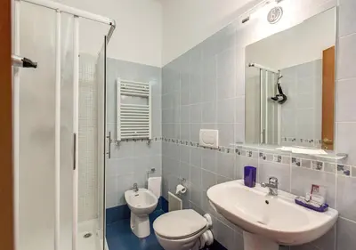 a bathroom with a sink and a toilet and a mirror at Bon Ton Design Rooms by DOT Suites in Rome