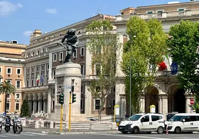 a statue in front of a large building with cars at Bon Ton Design Rooms by DOT Suites in Rome