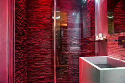 a bathroom with a shower with red brick walls at Pantheon Relais in Rome