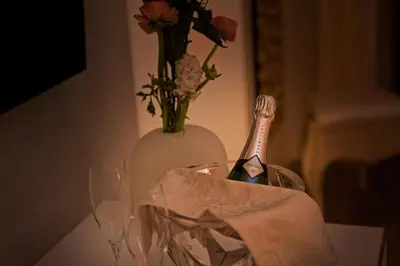 a bottle of wine and a vase with flowers on a table at Pantheon Relais in Rome