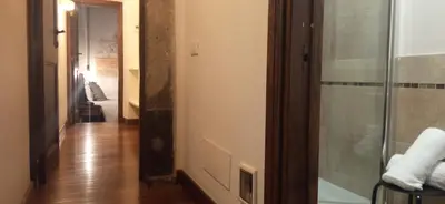 a bathroom with a glass shower and a hallway at Relais Giulia in Rome