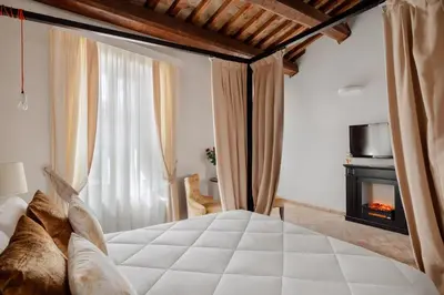 a bedroom with a white bed and a fireplace at Relais Giulia in Rome