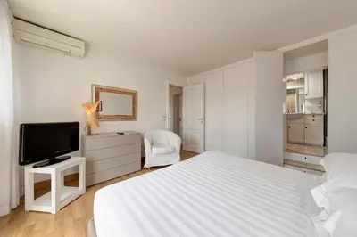 a white bedroom with a bed and a tv at Le case di Andrea Piccolomini San Peter - Terrace Flat in Rome