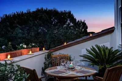 a patio with a table with wine glasses and lights at Le case di Andrea Piccolomini San Peter - Terrace Flat in Rome