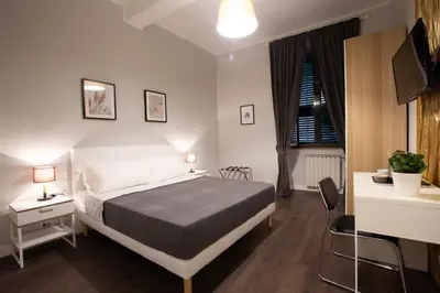 a bedroom with a bed and a desk and a television at maribea rome center in Rome