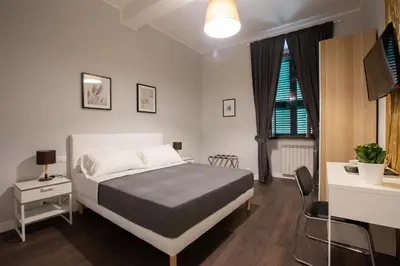a bedroom with a bed and a desk and a tv at maribea rome center in Rome