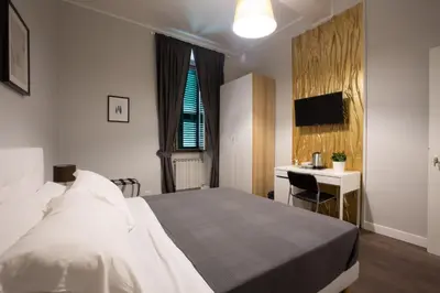 a bedroom with a bed and a desk and a television at maribea rome center in Rome
